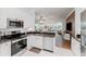Open kitchen features granite counters, stainless appliances, white cabinetry and view into living room at 2173 Caledonian St, Clermont, FL 34711