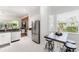 Stainless steel refrigerator and view into sunroom in kitchen with granite counters and white cabinets at 2173 Caledonian St, Clermont, FL 34711