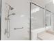Clean, white tiled shower with a glass door, grab bars, and two shower heads at 2173 Caledonian St, Clermont, FL 34711