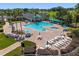 Aerial view of a sparkling community pool with a jacuzzi, lounging area, and lush greenery at 2173 Caledonian St, Clermont, FL 34711