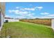 A view of the lush, green backyard featuring a white fence and no rear neighbors at 220 Foxtail Loop, Davenport, FL 33837