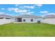 A view of the home's backyard, featuring a large lawn, privacy fence and screened in patio at 220 Foxtail Loop, Davenport, FL 33837