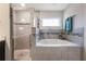Bathroom showcasing separate shower and soaking tub with decorative tile surround and a bright window at 220 Foxtail Loop, Davenport, FL 33837
