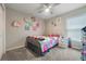 Cozy bedroom features a ceiling fan, plush carpet, and colorful decor at 220 Foxtail Loop, Davenport, FL 33837