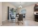 Cozy dining area with a glass table, modern chairs, and sliding glass doors to the backyard at 220 Foxtail Loop, Davenport, FL 33837