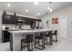 Well-equipped kitchen featuring dark cabinets, stainless steel appliances, and a spacious island with barstool seating at 220 Foxtail Loop, Davenport, FL 33837