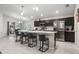 Stylish kitchen with dark cabinets, stainless steel appliances, and a large center island with seating at 220 Foxtail Loop, Davenport, FL 33837