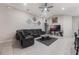 Cozy living room with a large gray sectional, tile floors, and a ceiling fan at 220 Foxtail Loop, Davenport, FL 33837