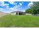 Spacious backyard with a well-manicured lawn, screened-in patio, and white perimeter fence at 2491 Wadeview Loop, St Cloud, FL 34769