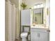 Cozy bathroom featuring a toilet with overhead storage, vanity, and shower with patterned curtain at 2491 Wadeview Loop, St Cloud, FL 34769