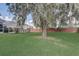 Lush backyard featuring mature trees and a screened-in pool enclosure, offering a private oasis at 2800 Woodsmere Ct, Kissimmee, FL 34746