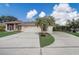 Long driveway leading to a two-car garage, adorned with palm trees, and a small storage shed at 2800 Woodsmere Ct, Kissimmee, FL 34746