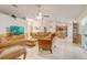 Open concept living room with tile floors, ceiling fan, and views into the dining and kitchen at 2800 Woodsmere Ct, Kissimmee, FL 34746
