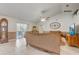 Cozy living room showcasing tile floors, a ceiling fan, and view of the screened lanai at 2800 Woodsmere Ct, Kissimmee, FL 34746