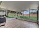 Enclosed patio with tile floors and ample natural light, showcasing the backyard and mature trees at 2800 Woodsmere Ct, Kissimmee, FL 34746