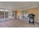 Covered patio with BBQ pit featuring tile floor, access to the back yard and a partial view of the pool at 2800 Woodsmere Ct, Kissimmee, FL 34746