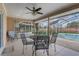 Enclosed patio featuring tile floor, ceiling fan, and black metal table and chairs overlooking the pool area at 2800 Woodsmere Ct, Kissimmee, FL 34746