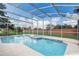 Screened in pool and spa with a patio and a beautiful manicured yard with a brick fence at 2800 Woodsmere Ct, Kissimmee, FL 34746