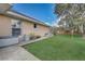 Side yard with lush green lawn, concrete walkway, and plants along the house at 2800 Woodsmere Ct, Kissimmee, FL 34746