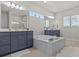 Bathroom with a large tub, double sink vanities and neutral tiling, creating a spa-like atmosphere at 3179 Sailing Pier Ave, Winter Garden, FL 34787