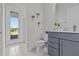 Bright bathroom with modern vanity, stylish plants, and walk-out access to the patio at 3179 Sailing Pier Ave, Winter Garden, FL 34787