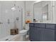 Bright bathroom featuring white tile walls, a glass shower, and a vanity with grey cabinets at 3179 Sailing Pier Ave, Winter Garden, FL 34787