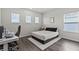 Neutral bedroom features three windows and a comfy, inviting bed at 3179 Sailing Pier Ave, Winter Garden, FL 34787