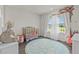 Charming Bedroom with a crib and decorative floral wall, creating a sweet and cozy space at 3179 Sailing Pier Ave, Winter Garden, FL 34787