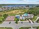 Aerial view of a community pool with palm trees, clubhouse, playground, and lake view at 3179 Sailing Pier Ave, Winter Garden, FL 34787