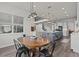 Bright dining area with a wooden table, stylish chairs, and views into the modern kitchen with a gray island at 3179 Sailing Pier Ave, Winter Garden, FL 34787