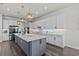 Beautiful kitchen features custom cabinets, stainless appliances, large island, and stylish pendants at 3179 Sailing Pier Ave, Winter Garden, FL 34787