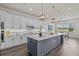 Spacious kitchen with quartz counters, large island, pendant lighting, and wood-look floors at 3179 Sailing Pier Ave, Winter Garden, FL 34787