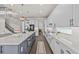 Modern kitchen features a large island, sleek white cabinets, stainless appliances, and wood-look floors at 3179 Sailing Pier Ave, Winter Garden, FL 34787
