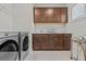 This laundry room is complete with a washer, dryer, and tons of cabinets at 3179 Sailing Pier Ave, Winter Garden, FL 34787