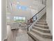 Bright living room featuring carpeted stairs, and a seating area with large windows showcasing scenic outdoors at 3179 Sailing Pier Ave, Winter Garden, FL 34787