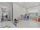Large playroom with a white bookshelf, toys, a playhouse, and view to a golf course at 3179 Sailing Pier Ave, Winter Garden, FL 34787