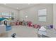 Spacious playroom with lots of light and toys, including a play kitchen, playhouse, and table at 3179 Sailing Pier Ave, Winter Garden, FL 34787
