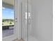 Walk-in shower featuring bright white tile and a glass door to a sunny patio at 3179 Sailing Pier Ave, Winter Garden, FL 34787