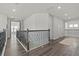 Upstairs hallway with dark wood floors and decorative wrought iron railing at 3179 Sailing Pier Ave, Winter Garden, FL 34787