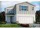 Two-story home featuring a gray exterior, complemented by a white garage door and manicured landscaping at 3674 Portsmouth Ln, Haines City, FL 33844