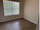 Bright bedroom featuring wood laminate floors and a large window with blinds at 3713 S Lake Orlando Pkwy # 6, Orlando, FL 32808