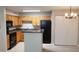 Cozy kitchen featuring wood cabinets, dark countertops, and black appliances with dining area to the right at 420 Forestway Cir # 202, Altamonte Springs, FL 32701