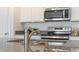 Close up of a kitchen sink featuring granite countertops, stainless appliances, and white cabinets at 5174 Masser Rd, St Cloud, FL 34772