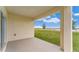 A covered patio with a view of the lawn and young trees on a sunny day at 5174 Masser Rd, St Cloud, FL 34772