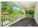 View of balcony with dark floors, white railing, and sunny green views at 5552 Remsen Cay Ln, Windermere, FL 34786