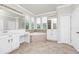 A luxurious bathroom with a soaking tub, double vanity, and tiled floors at 5552 Remsen Cay Ln, Windermere, FL 34786