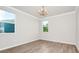 Bedroom with light wood-look flooring, chandelier, and two windows at 5552 Remsen Cay Ln, Windermere, FL 34786