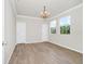 An empty bedroom with light wood-look flooring, chandelier, and two windows at 5552 Remsen Cay Ln, Windermere, FL 34786