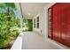 Charming front porch with red door and views of lush greenery at 5552 Remsen Cay Ln, Windermere, FL 34786