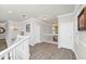 Bright hallway featuring elegant chandeliers, hardwood floors, and white trim throughout at 5552 Remsen Cay Ln, Windermere, FL 34786